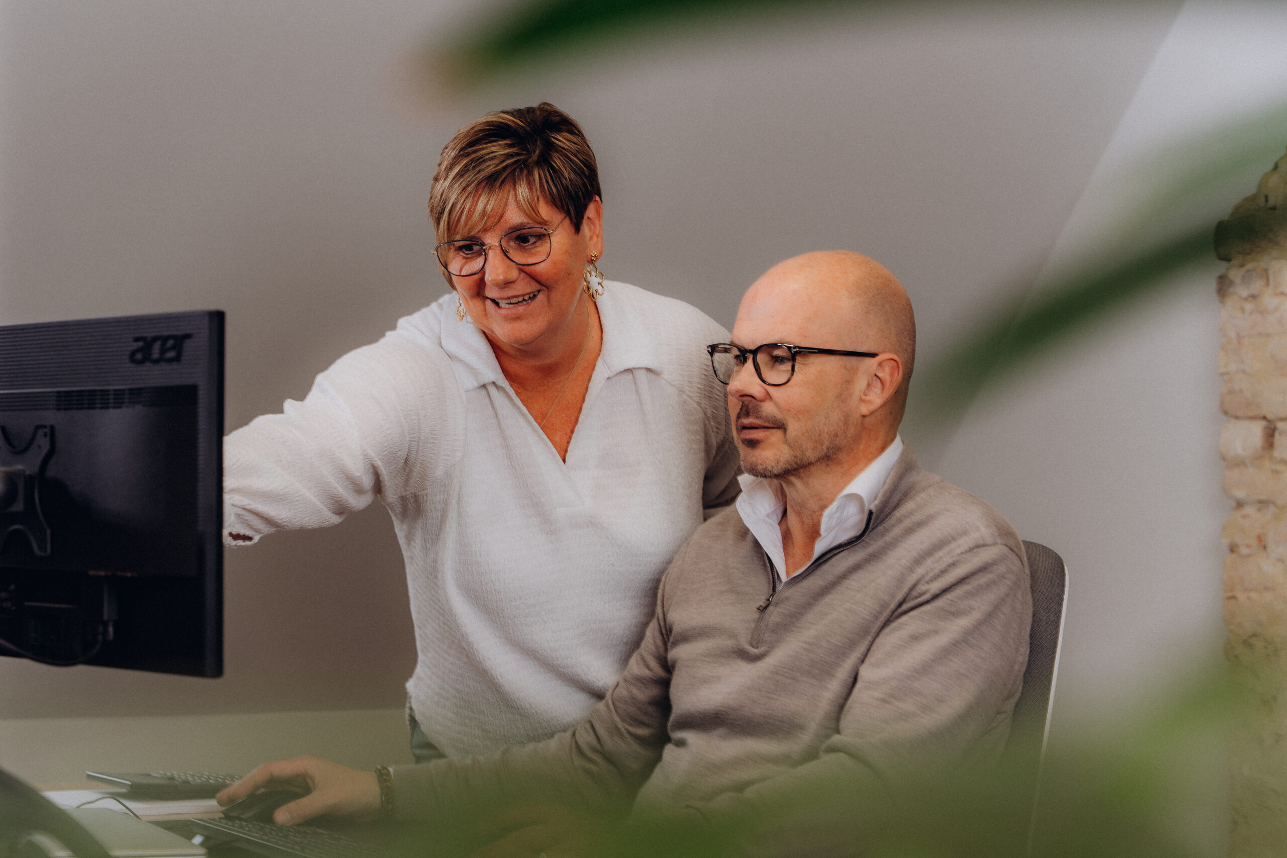 Lachende Midglas collega's achter een computer