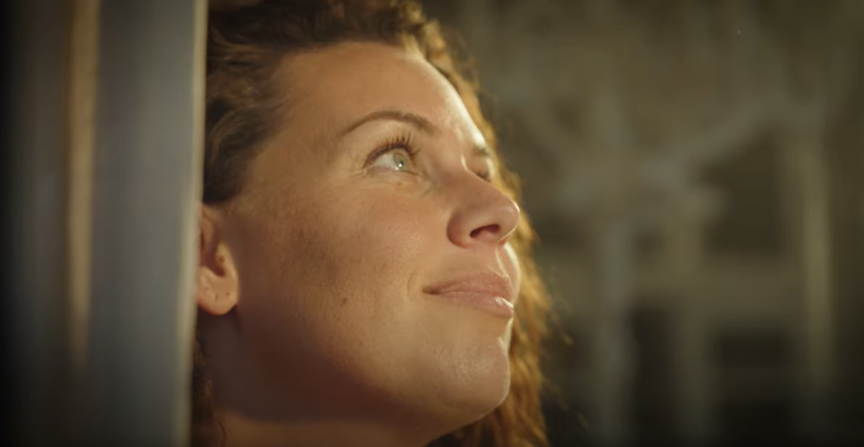 Vrouw die genietend uit een raam kijkt | Thumbnails bedrijfsfilm